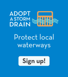 Blue graphic with text: "Adopt a Storm Drain. Protect local waterways." An orange storm drain icon with blue water lines appears above a white "Sign up!" button—part of our Stormwater Management Program.